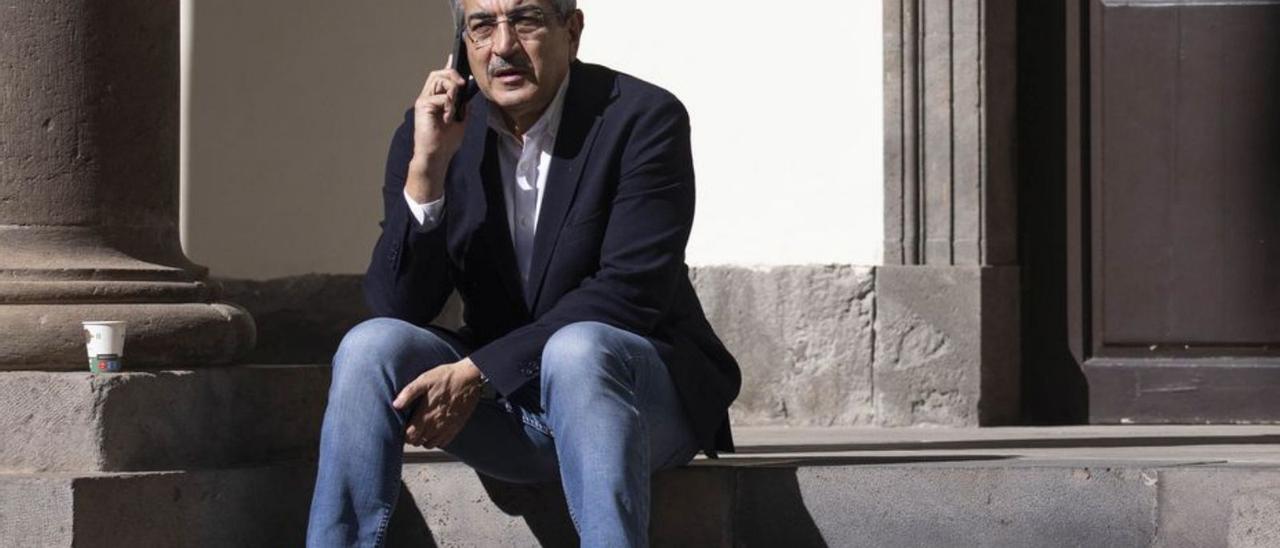 Román Rodríguez habla por teléfono en las escaleras del patio del Parlamento.