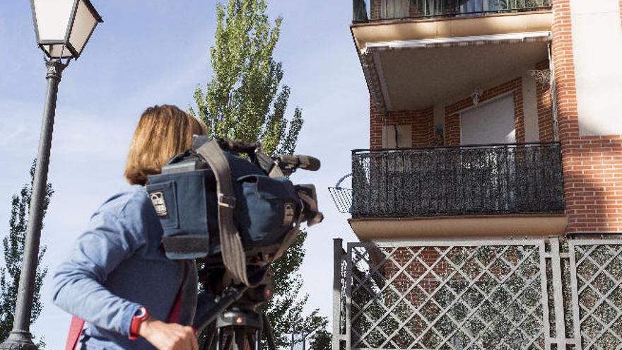 Una cámara de televisión graba delante del domicilio de la mujer fallecida en la localidad de Arévalo.