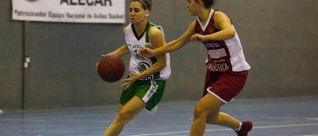 Una jugadora del Avilés Basket conduce el balón ante una baloncestista del Innobasket durante el derbi local.