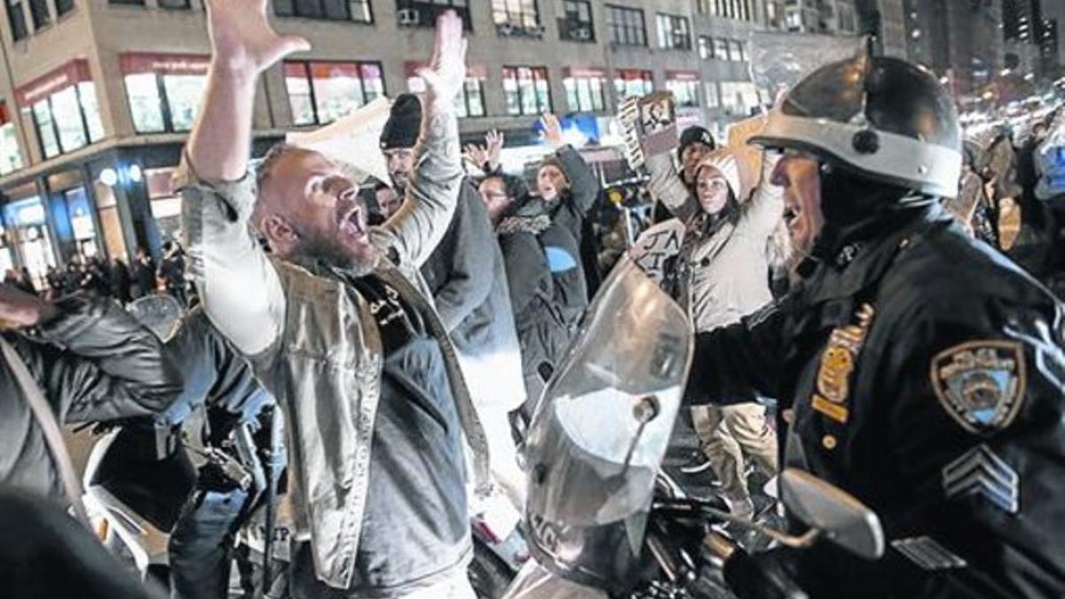 Un manifestante se encara a un policía antidisturbios en la Sexta Avenida de Nueva York durante la protesta por el fallo judicial, este miércoles.