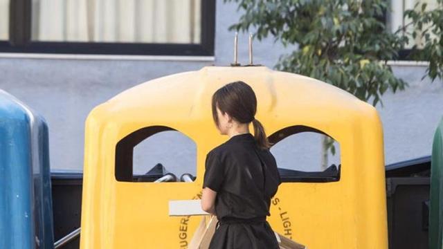 Una dona diposita envasos de plàstic al contenidor groc. | EFE