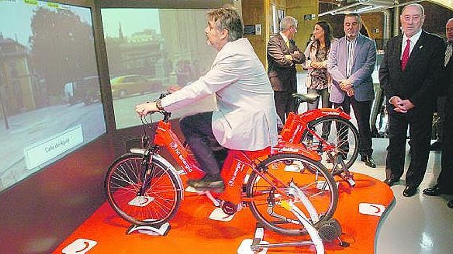 Uno de los técnicos de la empresa que ha diseñado el museo prueba la bicicleta de la Fundación Hidrocantábrico con la que se puede hacer una ruta por Oviedo sin salir del centro inaugurado ayer.