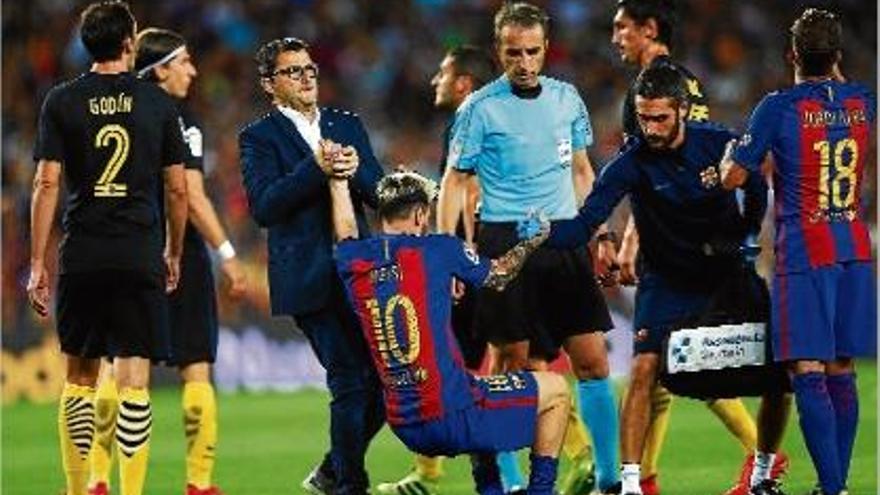 Messi és ajudat a aixecar-se pel metge del Barça abans de ser substituït per lesió dimecres a l&#039;estadi.