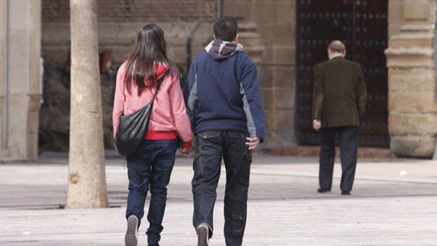 Una pareja pasea por una calle de la capital.