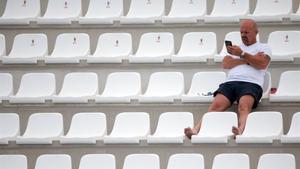 Un hombre espera el inicio de un partido en Tarragona.