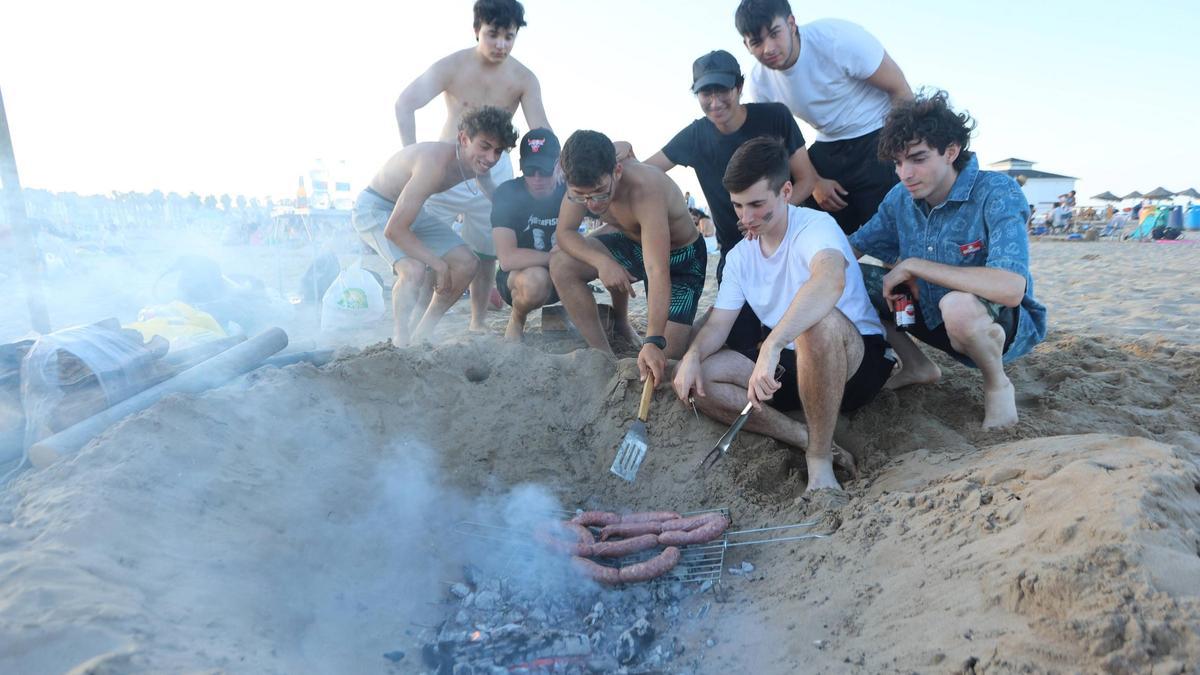 Un grupo de jóvenes, con su fogata, en la fiesta de la playa