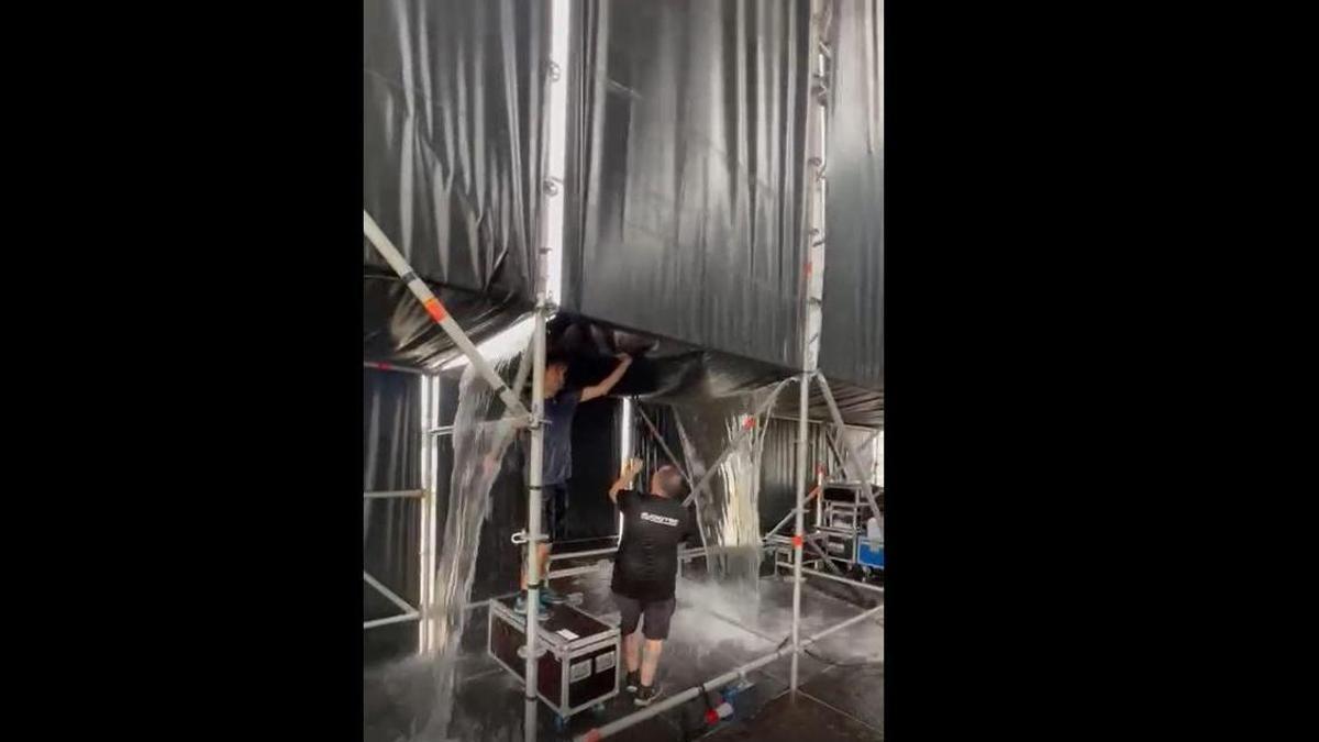 Dos operarios tratan de achicar agua en el escenario de La Real, en Yecla.