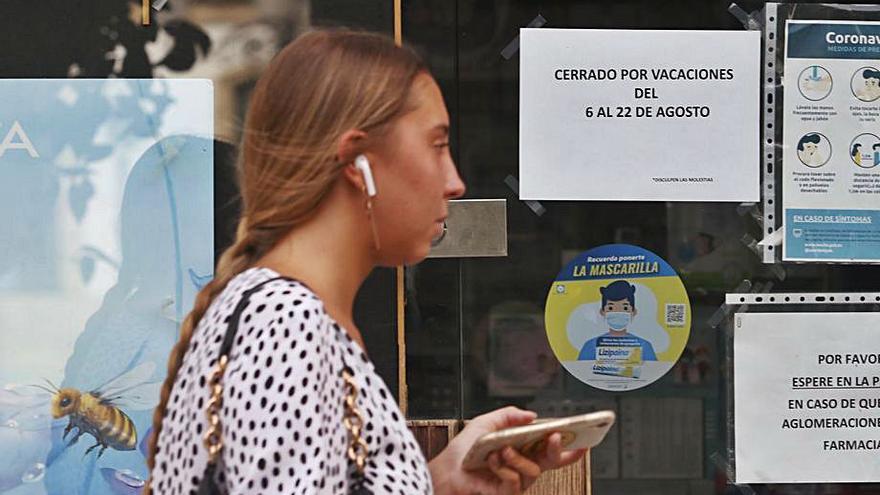 Vacaciones | Una joven pasa de largo en un local en días de vacaciones.