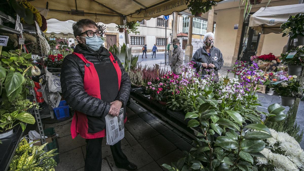 Azucena Suárez en su puesto de flores del Arco de los Zapatos