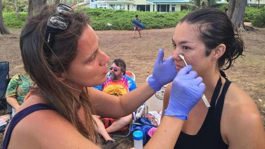 Iria Fernández recoge muestras del rostro de una voluntaria.