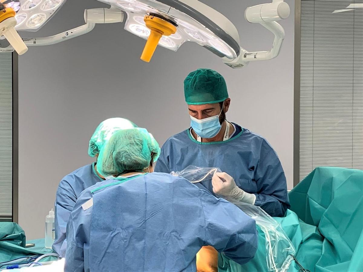 Los doctores Espiñeira (de espaldas) y Contreras, realizando una biopsia de ganglio centinela en quirófano.