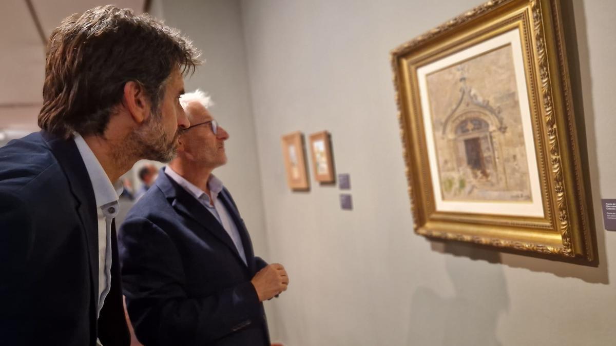 El concejal de Cultura de València, José Luis Moreno, en primer término, observa uno de los cuadros
