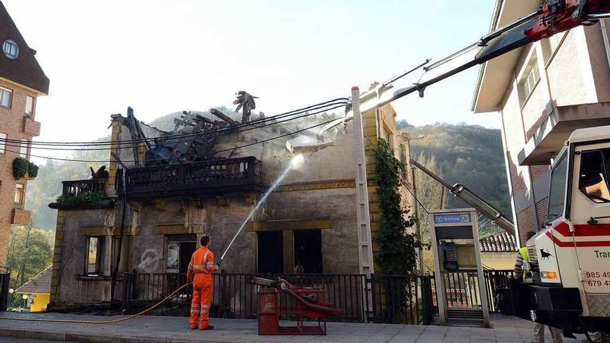 Un operario riega la fachada del chalé de La Cadena durante la demolición.