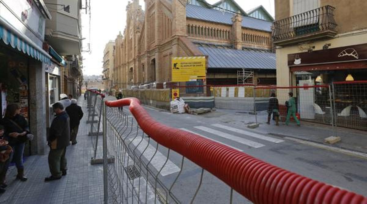 Aspecte de les obres de reurbanització dels entorns del mercat de Sants, amb el mercat al fons, ahir al matí.