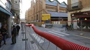 Aspecte de les obres de reurbanització dels entorns del mercat de Sants, amb el mercat al fons, ahir al matí.