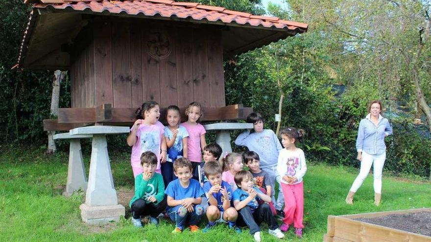 Varios alumnos del San Félix posan junto al hórreo instalado en el patio del colegio con su directora, Begoña García, a la derecha de la imagen.