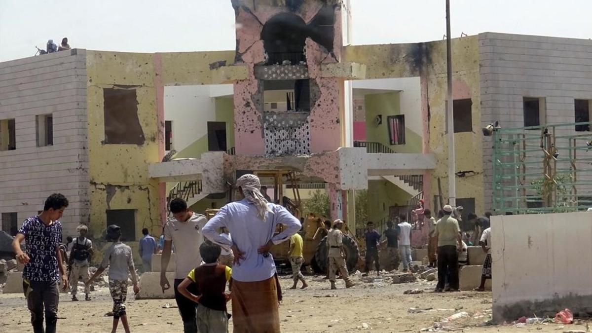 Los gente se reúne alrededor del escenario del atentado suicida que ha tenido lugar en la ciudad de Adén, en el sur de Yemen, el lunes.