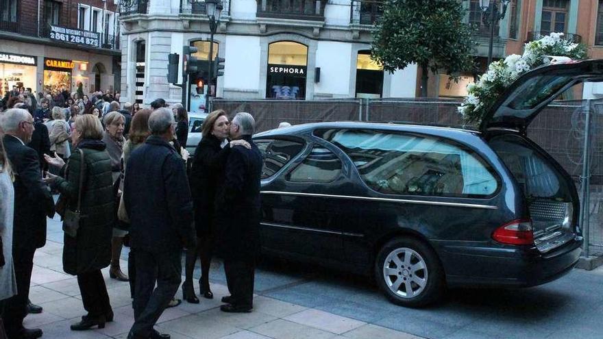 La viuda, María del Mar Navarro, recibiendo condolencias junto al coche fúnebre, ayer, en San Juan el Real.