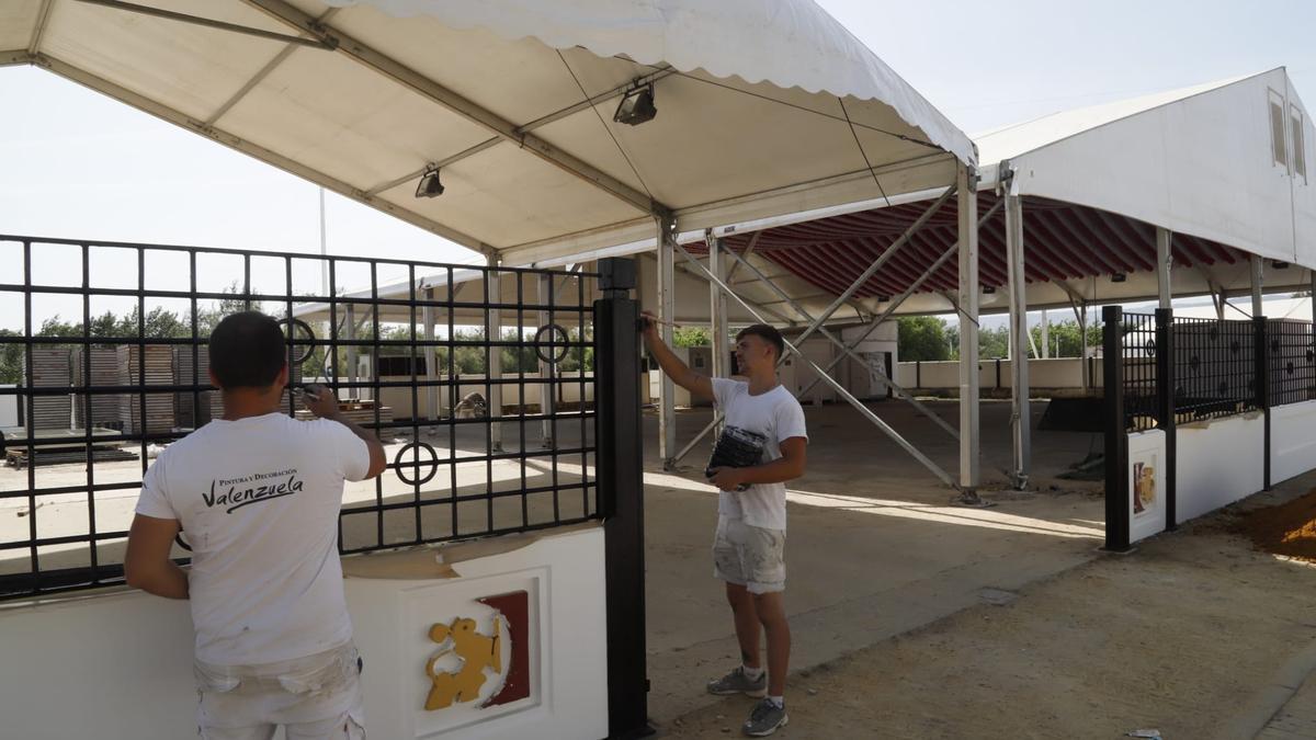 Operarios pintan y adecentan las rejas de la caseta de la Diputación de Córdoba.