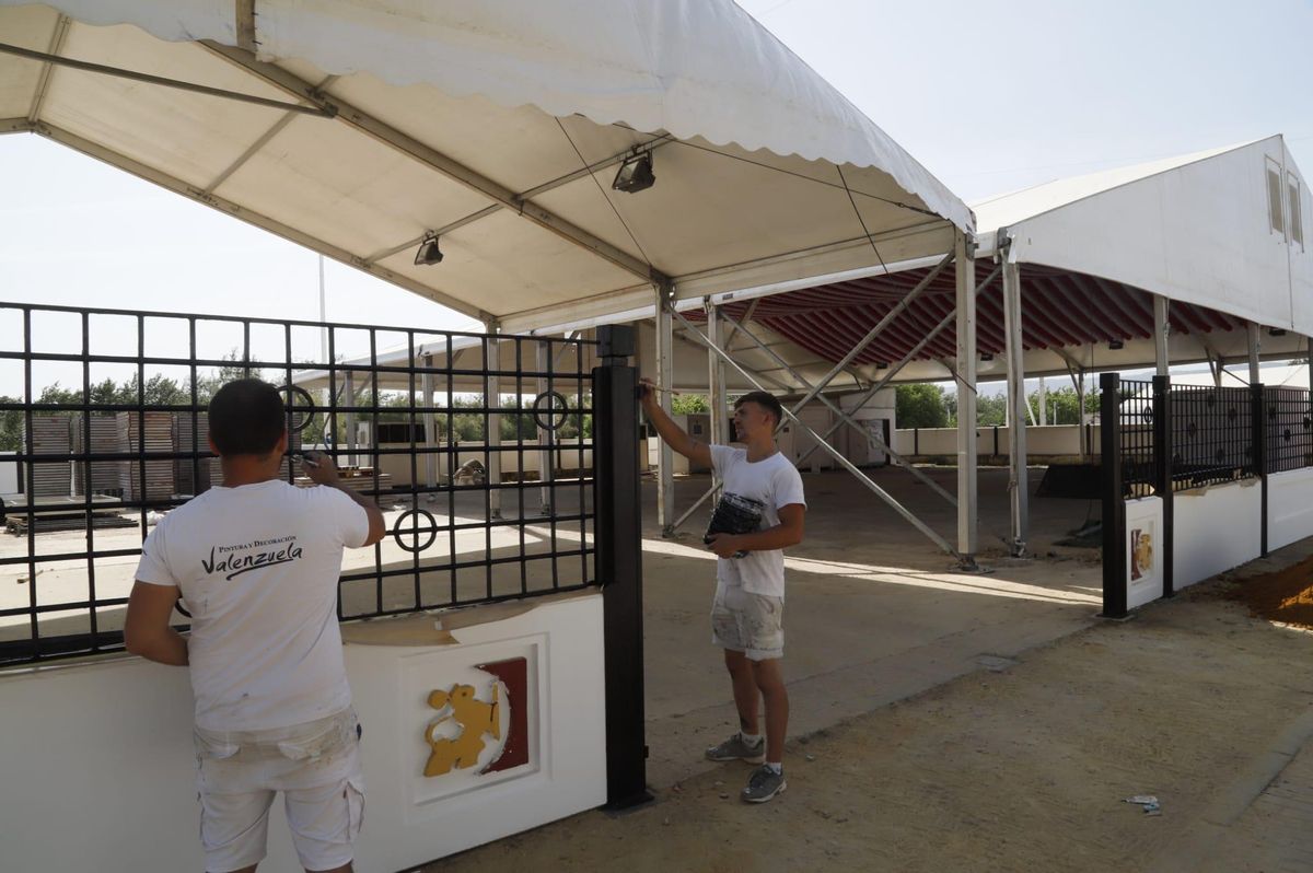 Operarios pintan y adecentan las rejas de la caseta de la Diputación de Córdoba.