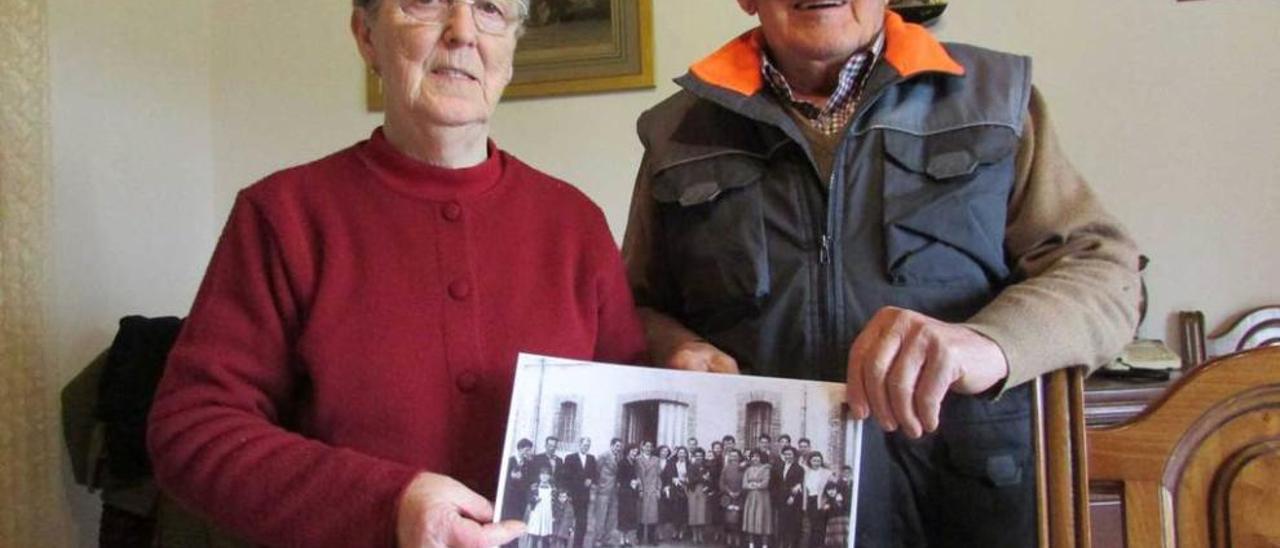 Julia Villa Carrera y Benjamín Obeso Nieda, ayer, en su casa de Naves, con una foto de su boda, en 1956.