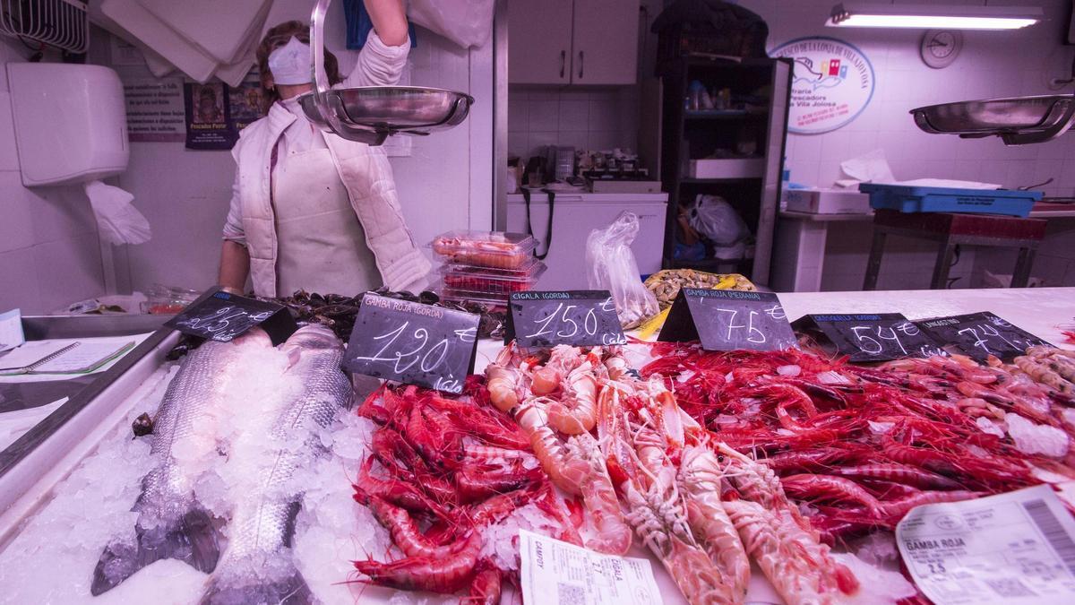 Dos de los vendedores de marisco que ofrecen gamba roja y cigalas en el Mercado Central de Alicante a 120 y 150 euros el kilo. Los crustáceos más caros se agotaron.