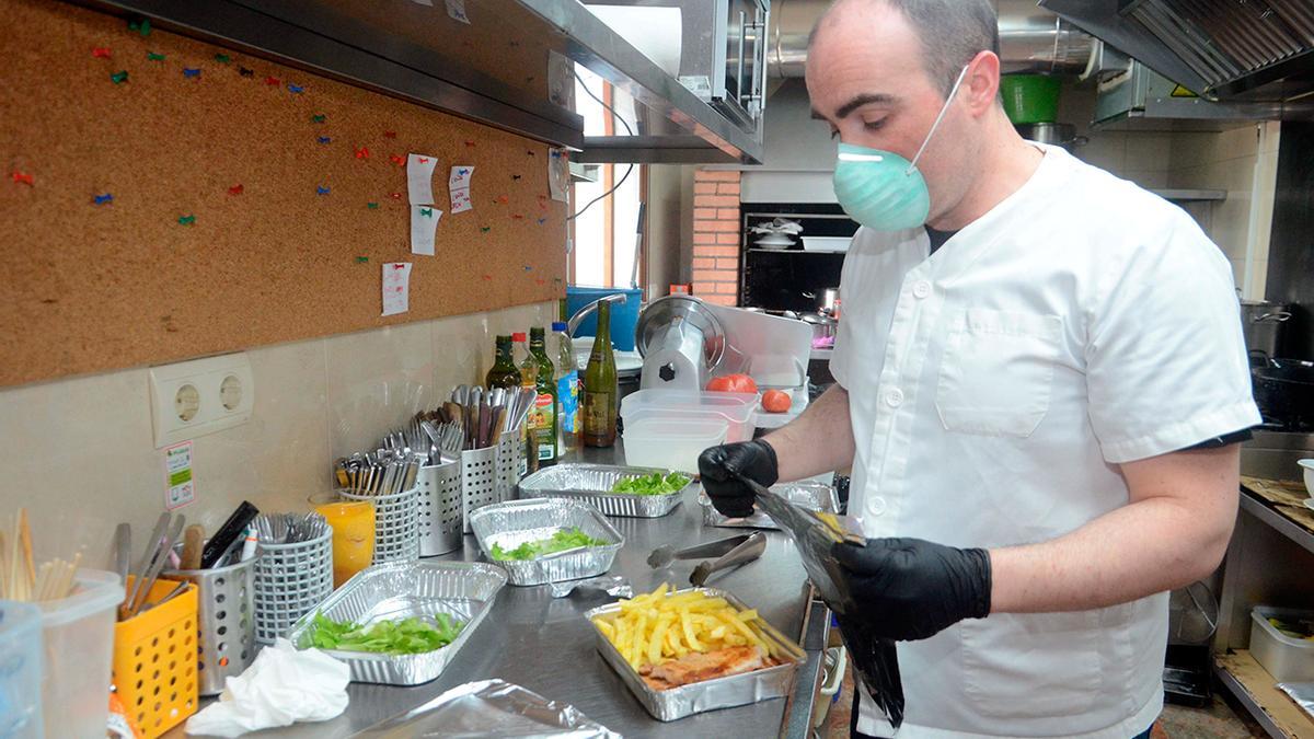 El empleado de un restaurante en Galicia prepara una táper con comida para llevar