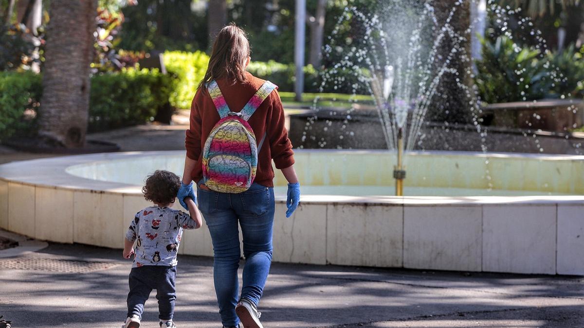 Un niño pasea de la mano de su madre.