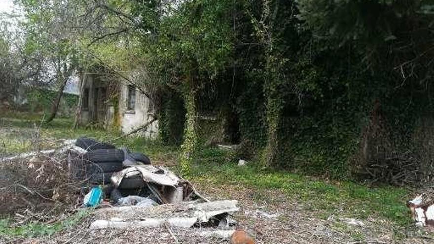 Basura en la finca anexa a la parada de Abades, papelera llena y pintadas en el edificio principal.  // S.S.