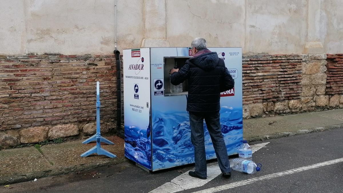 Un vecino llena una garrafa de agua en la potabilizadora instalada en San Francisco