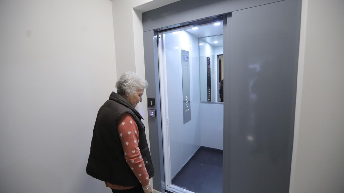 Una mujer entra en el ascensor en uno bloque de edificios de Córdoba.