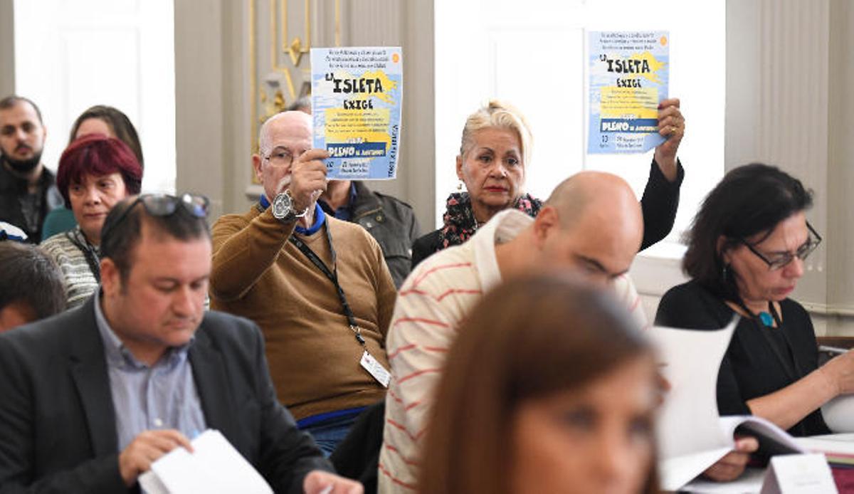 Vecinos de La Isleta realizan sus denuncias levantando carteles en el pleno de ayer.