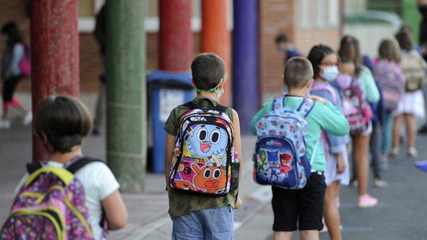 Un grupo de niños espera para entrar en clase.