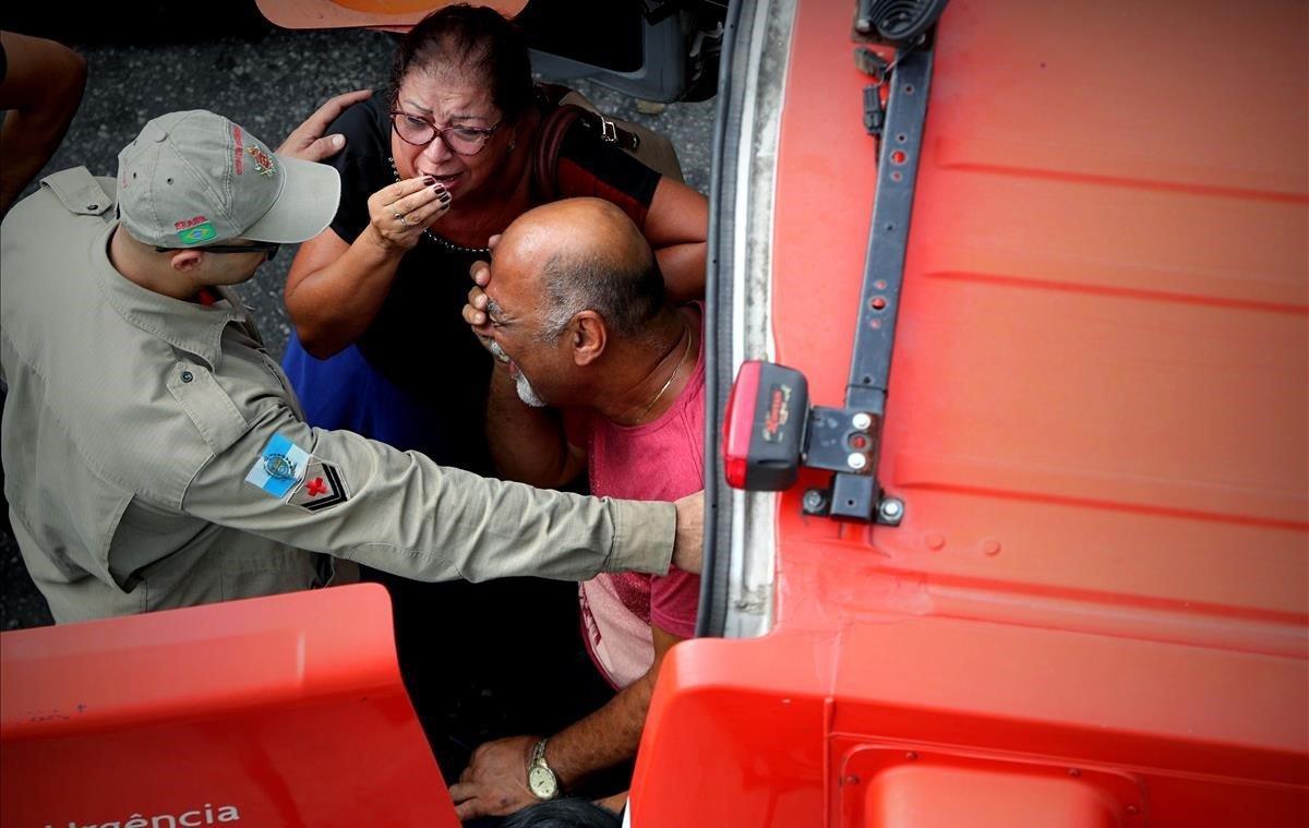 Un bombero comunica la muerte del conductor de uno de los trenes que colisionaron frontalmente, tras estar 7 horas atrapado, a sus padres este miércoles, en Río de Janeiro (Brasil). El conductor de uno de los trenes falleció tras pasar 7 horas atrapado entre los hierros. Al menos ocho personas resultaron heridas este miércoles tras la colisión frontal de dos trenes de pasajeros en una estación de Río de Janeiro.