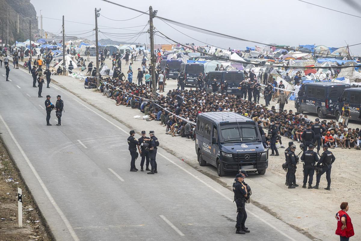 Agentes de la Policía Nacional intervienen durante el proceso de desalojo del embolsamiento de migrantes en la playa de El Trampolín, a 4 de octubre de 2026, en Ceuta (España).
