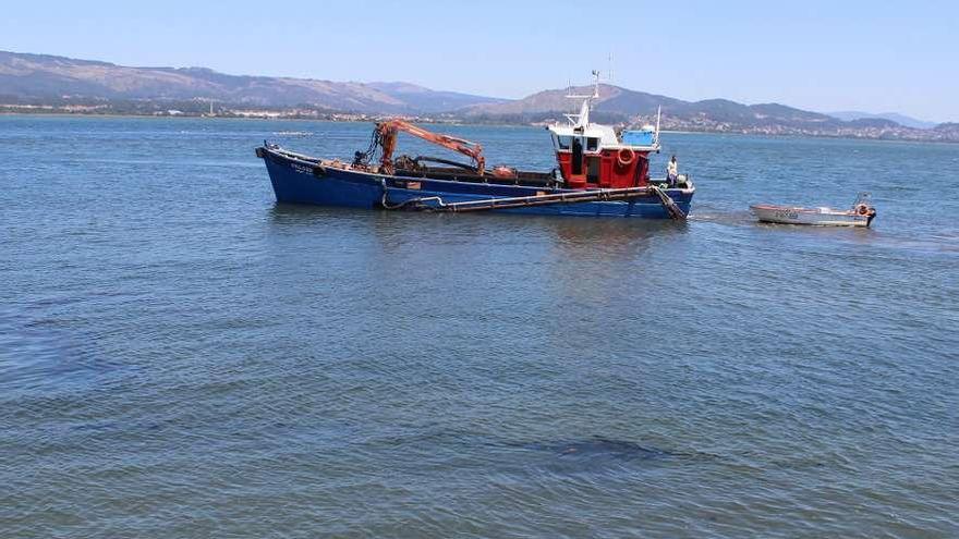 Embarcación que realiza los trabajos de dragado en la zona del muelle de Caminha.