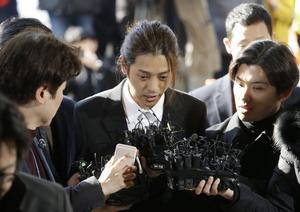 FILE - In this March 14, 2019, file photo, K-pop singer Jung Joon-young, center, speaks upon his arrival at the Seoul Metropolitan Police Agency in Seoul, South Korea. A South Korean court has found two K-pop stars guilty of illicit sexual relations with a woman who was unable to resist and sentenced them to up to six years in prison. The Seoul Central District Court says singer-songwriter Jung received a six-year prison term.  (AP Photo/Ahn Young-joon, File)