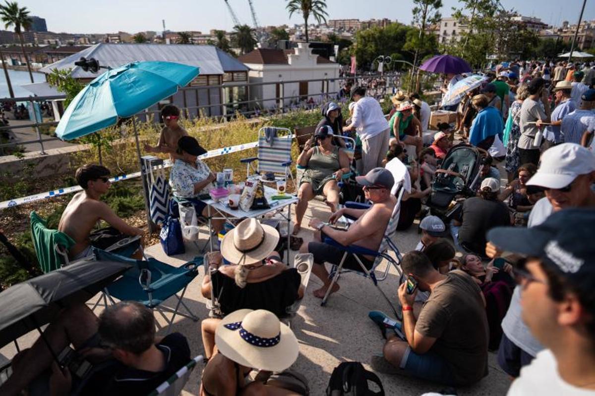 Visitantes y aficionados a la observación astronómica esperan en el Port de la Maria, en Tarragona, para contemplar el eclipse total de Sol.