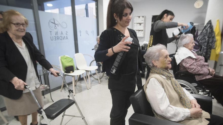 La perruqueria un dimarts al matí, amb Verónica Martínez, en primer terme, les clientes i la seva ajudant