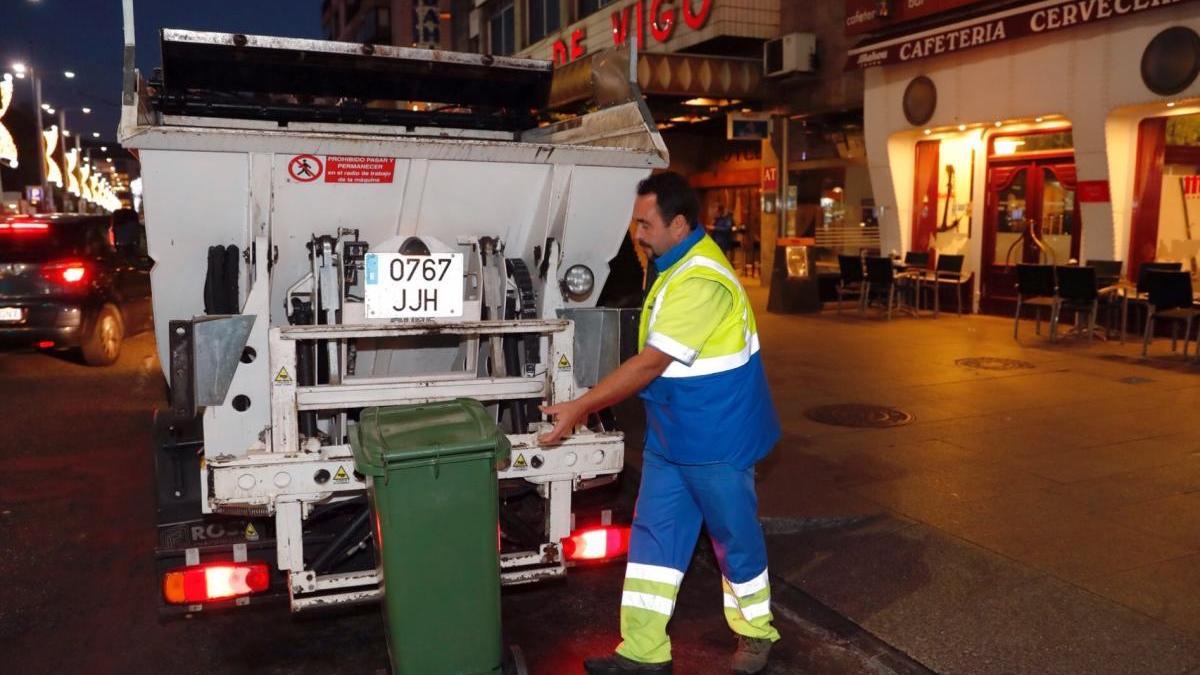 Un trabajador recogiendo un contenedor de basura en Vigo. // J. Lores