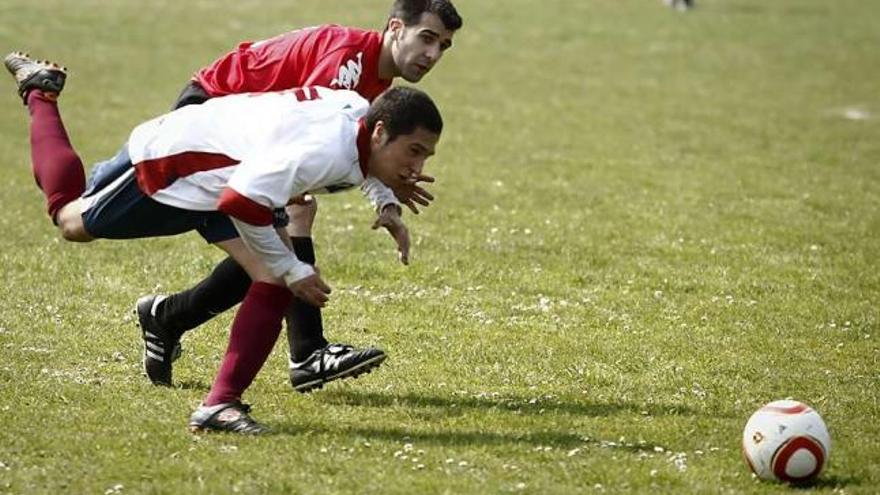 El jugador del Luarca Borja Arroyabe disputa el balón con un futbolista del Industrial.