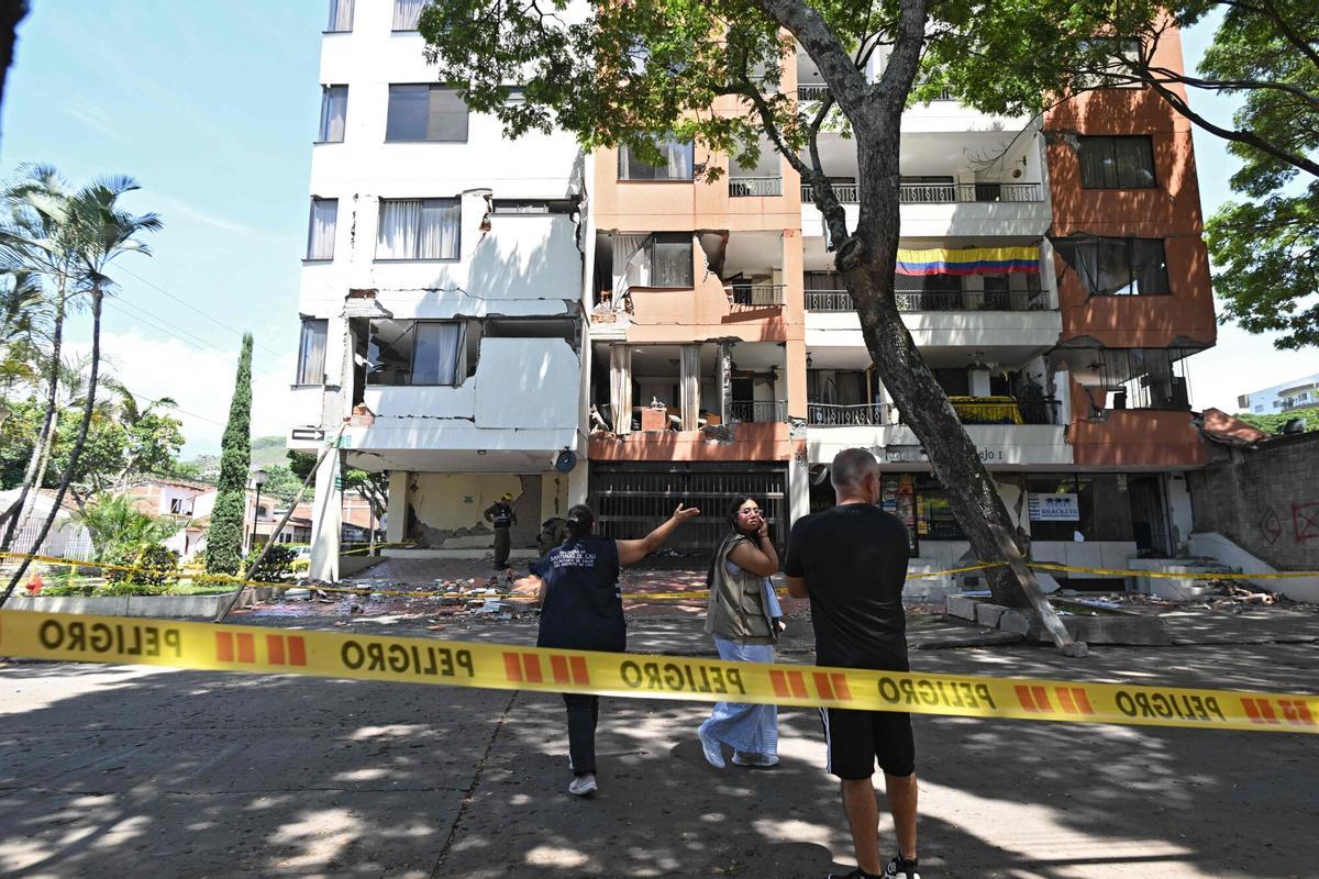 Varias personas se encuentran frente a un edificio dañado en el barrio de Cuarto de Legua, en Cali (Colombia), el 20 de agosto de 2026, diez días después de un terremoto de magnitud 7,4.