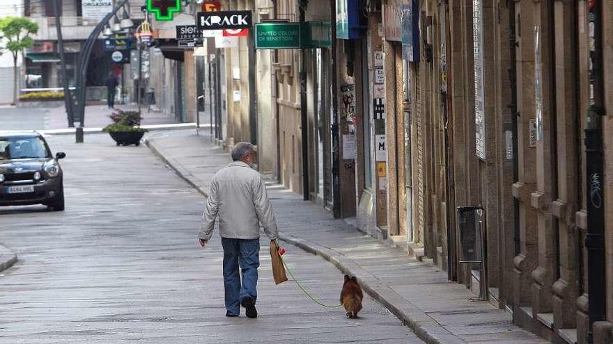 Un hombre pasea con su perro en la calle Santo Domingo. // Iñaki Osorio