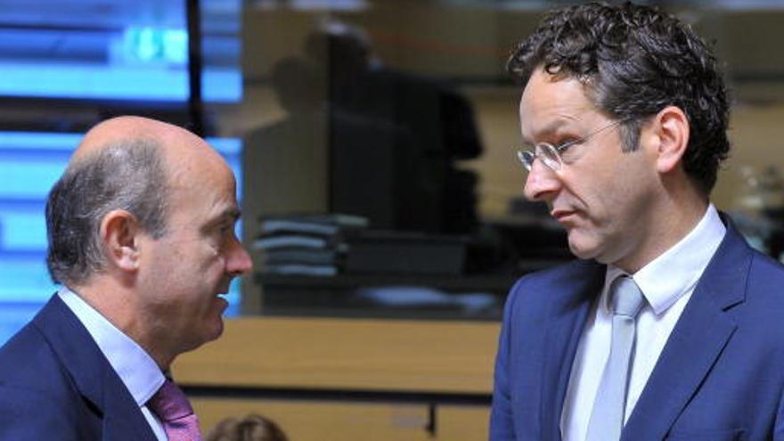 De Guindos (i), conversa con el presidente del Eurogrupo, Jeroen Dijsselbloem.