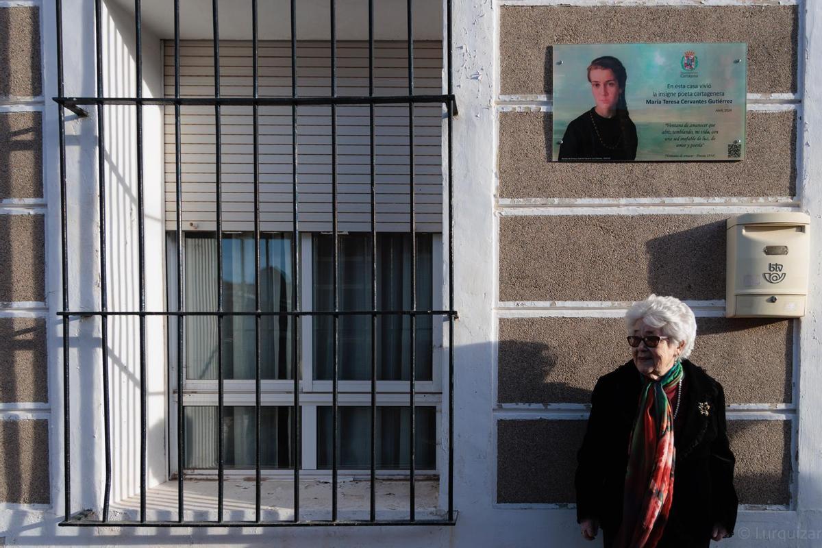 Cervantes, junto a la placa en su honor.