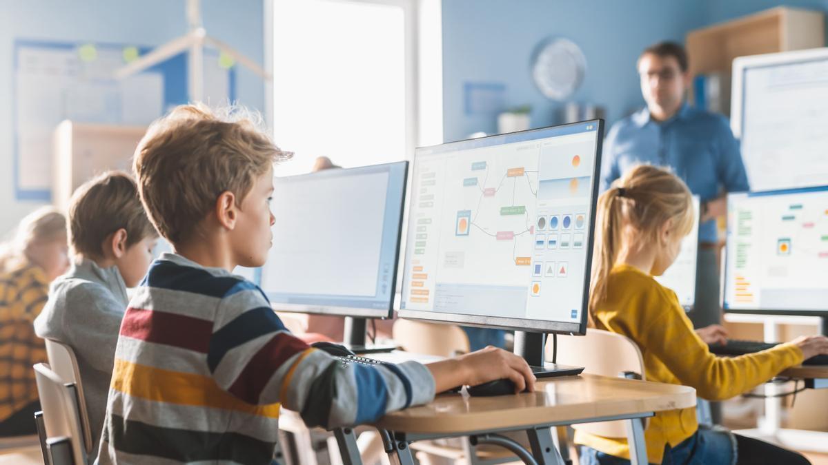 Unos niños en clase trabajando con el ordenador