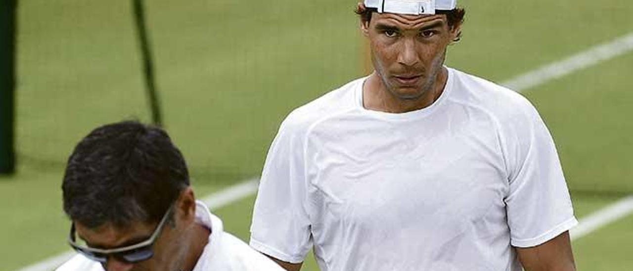 Toni Nadal, en primer término, pensativo junto a su sobrino, en un entrenamiento.