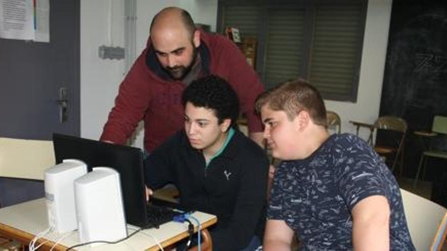 El professor Isaac Aureli treballant les aplicacions amb dos alumnes del centre.