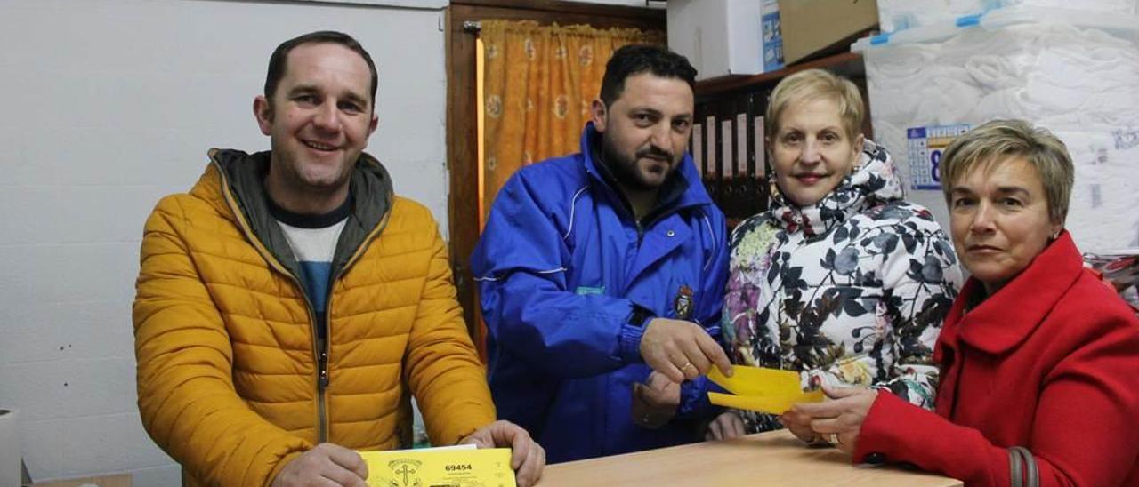 José Luis Tamargo y Marcos Fernández entregan la lotería a María Jesús Blanco y María Jesús Alonso.