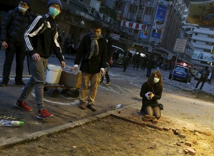 Protesters break a pavement for bricks to be thrown at riot police at Mongkok district in Hong Kong,